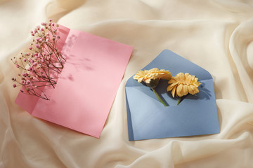 Pink and Blue envelope with a spring flower arrangement. Flat lay, top view