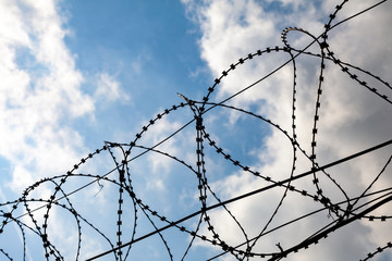 Barbed wire against a cloudy sky