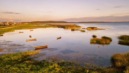 Fototapeta na wymiar Boats on lake in sunny summer evening, sunset light