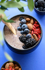 Healthy blueberry smoothie bowl on blue background