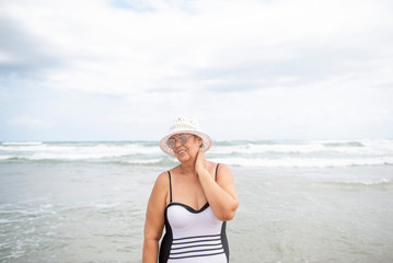 Beautiful mature woman posing on the beach