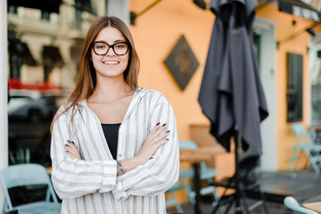 small business owner in front of a cafe smiling