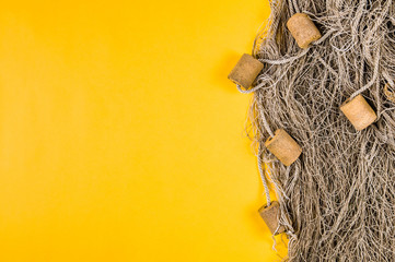Old fishing net on yellow background. Space for text or design