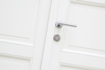 Silver aluminium modern metal handle on a white wooden door