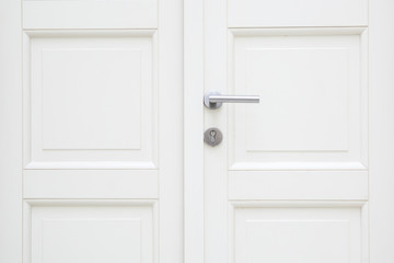 Silver aluminium modern metal handle on a white wooden door