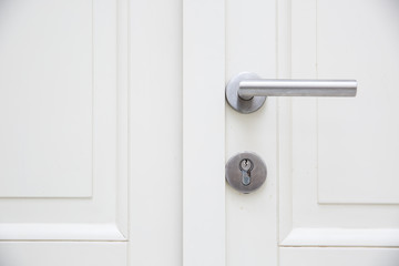 Silver aluminium modern metal handle on a white wooden door