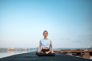 Girl practice yoga early morning on pier