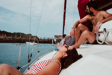 Young beautiful couple enjoying a relaxing morning on a sailboat showing their love in the ocean. Travel photography. Lifestyle