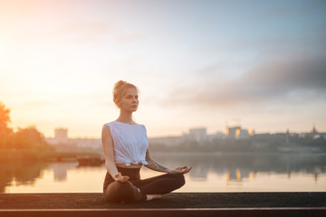Girl practice yoga early morning on pier