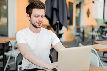 Fototapeta premium man using laptop for remote work in cafe