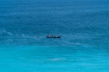 Fishing boat in the sea. Boat on the sea waves. Blue background.