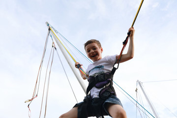 Happy child jumping on bungee trampoline