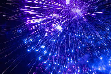 Multicolour fireworks in the night sky. Blue, violet and purple fireworkss
