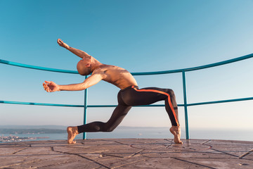 Young beautiful male ballett dancer posing by the sea