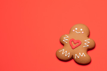 Christmas Gingerbread man biscuit with red heart icing on red background