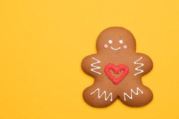 Christmas Gingerbread man biscuit with red heart icing on yellow background