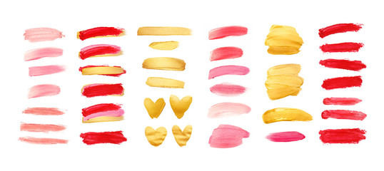 Set of gold, living coral and red strokes isolated on white background. Lipstick bullet smudged. Beautiful textured brush strokes and hearts. Living coral - color of the year 2019.