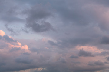 Black clouds coming from top to mixed black and white cloud cover. Sunset light. Background.