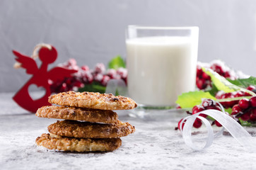 Tasty homemade cookies and glass of milk, traditional Christmas snack on the grey table. Christmas ornaments and food
