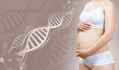 Pregnant woman caress belly among DNA stems.
