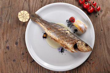Fried Sibas fish on a white plate