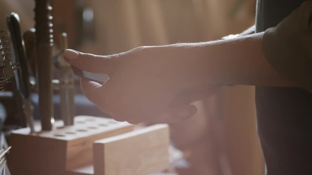 Close up of worker hands preparing tools for work with leather