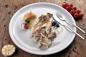 Fried Sibas fish on a white plate