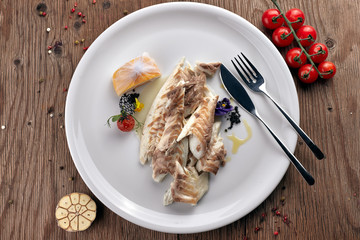 Fried Sibas fish on a white plate