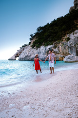 couple men and woman on summer vacation Sardinia, couple on the ebach of Cala Goloritze Sardegna Italy