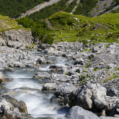 mountain stream in flow with rocks and stones
