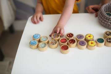 Caucasian blonde mother teaches child with wooden