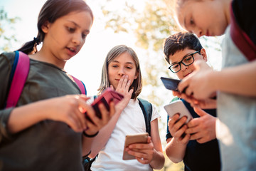 Kids playing video games on smart phone after school