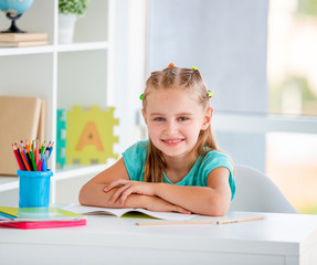 Portrait of cute little girl in school classroom