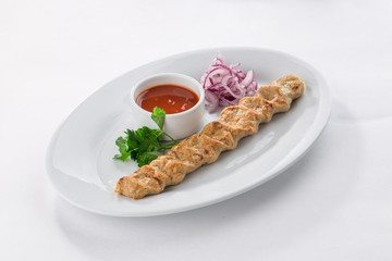 Homemade chicken Kofta kebabs on skewers withnred onion and parsley isolated on white background