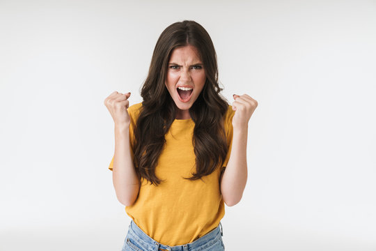 Image of emotional brunette woman wearing casual t-shirt screaming and clenching fists