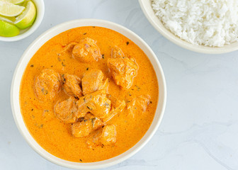 Indian Butter Chicken with Rice and Lemon in the Bowls on WHite Background Top Down Photo.