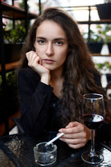 Closeup portrait of long haired curly beautiful girl. With cigarete .Smoking.