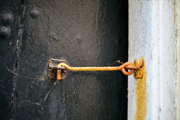 Rusty hook on old wooden door. Close up