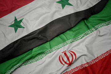 waving colorful flag of iran and national flag of syria.