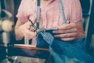 female tailor hands using scissors at home