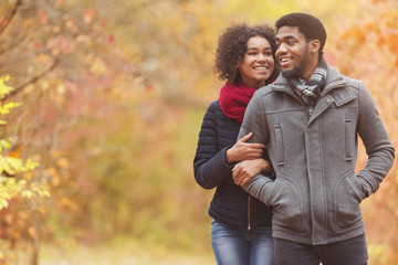 Loving afro couple dating in park, enjoying autumn day - obrazy, fototapety, plakaty