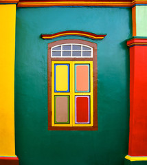 Colourful wooden shutters on a green wall.