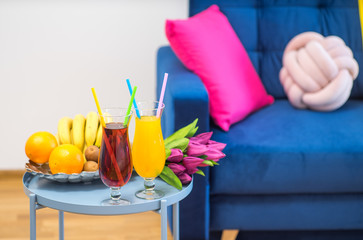Romantic composition of fruits, flowers and cocktails on the small table.