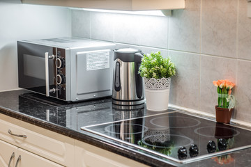 Close-up of home appliances. Microwave. Kettle. Induction cooker.