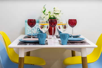 Close-up of the served table with wine glasses, cups and plates.