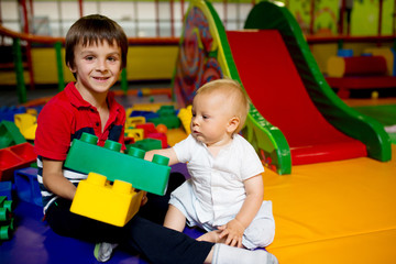 Fototapeta na wymiar Little toddler child, playing in childrens playground indoors