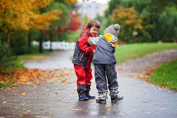 Fototapeta premium Two children, fighting over toy in the park on a rainy day