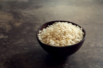 Raw Arborio rice in a bowl still life background