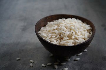 Raw Arborio rice in a bowl still life background