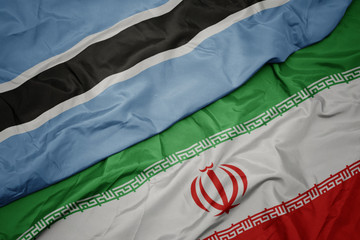 waving colorful flag of iran and national flag of botswana.